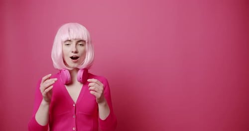 Woman with Pink Wig and Headphones Smiles