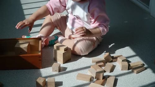 Criança empilhando blocos de brinquedos de madeira na varanda - menina multiétnica asiática coreana-ucraniana