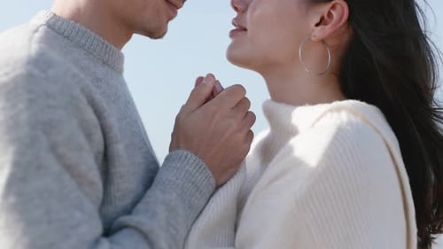 Affectionate Couple Holding Hands on Beach in Sunlight