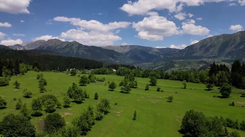 Aerial View of Green Meadow and Distant Mountains