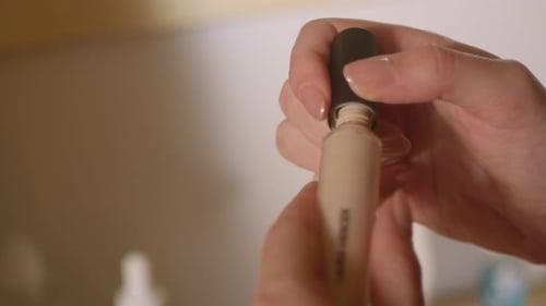 Hands Twist Cap onto Concealer Tube