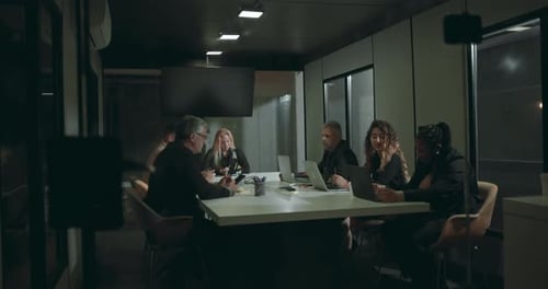 Business Colleagues Collaborate at Night in Urban Office