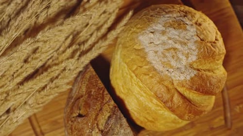 Rustic Bread and Wheat on Cutting Board