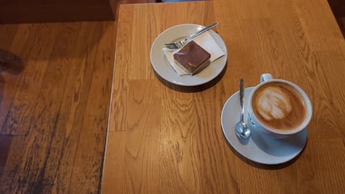 Cappuccino and chocolate brownie on wooden table top