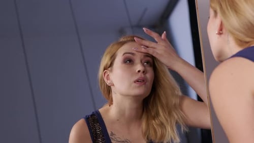 Woman Inspects Makeup in Front of Mirror