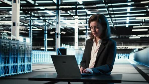Data Center Engineer Typing on Laptop Keyboard to Troubleshoot Issues