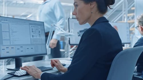 Back View of Team of Technology Engineers Working on Desktop Computers in Bright Office. Screens Sh