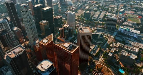 Tops of Los Angeles skyscrapers with helicopter platforms on. Flight above city downtown at daytime.