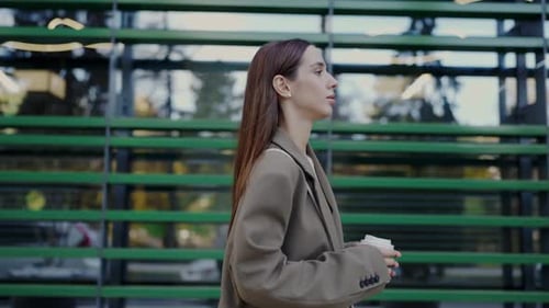 Confident Woman Walking with Coffee in City