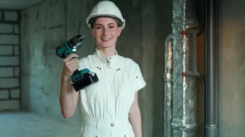 Young Girl Dressed for Repairs is Standing and Holding a Screwdriver in Her Hand Tools for Girls and