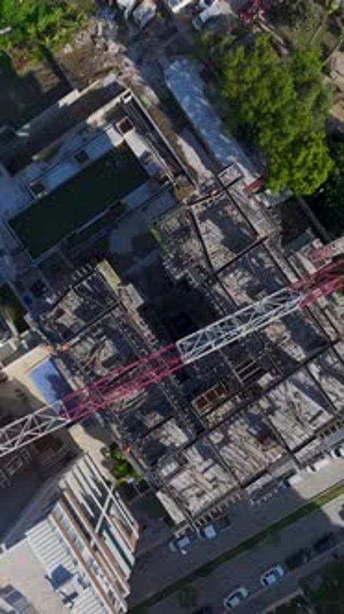 Vertical Video Aerial View of Workers Handling Metal and Assembling Walls on a Busy Construction