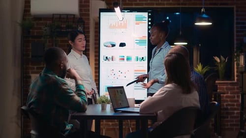 Business Team Reviews Data at Night Meeting