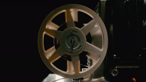Vintage Film Projector Reel Spinning in Dark Room