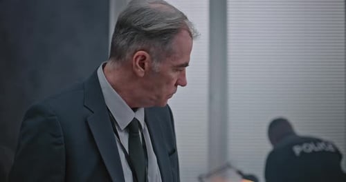 Man in Suit Crouching in Messy Office