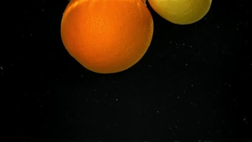 An Orange and a Lemon Fall Under the Water Filmed on a Highspeed Camera at 1000 Fps