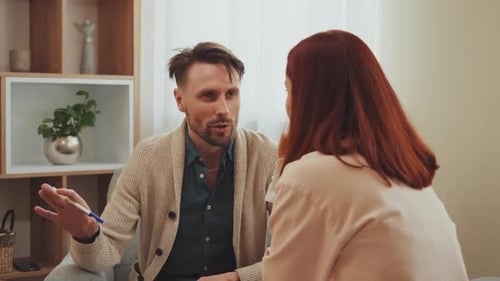 Man Talking With Woman in Counseling Session Indoors