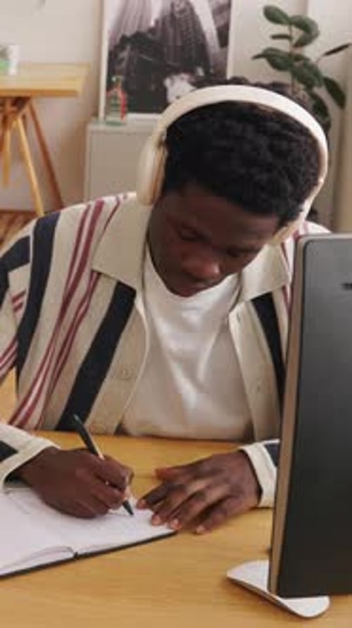 Man writing in notebook at his desk