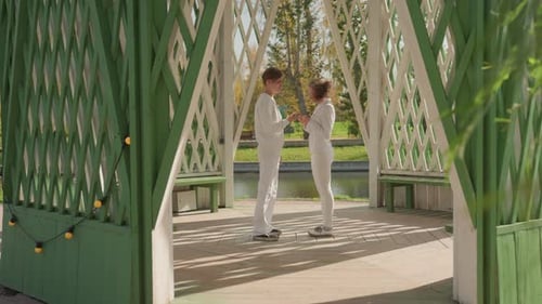 Teen Couple Embrace and Kiss in Park Gazebo