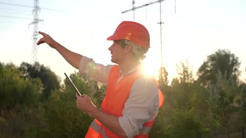 Construction Worker Using Tablet and Pointing Upward
