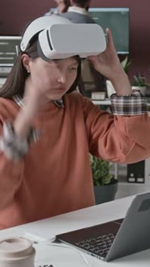 Asiatische Programmiererin mit Headset arbeitet an AR-Anwendung bei IT-Startup