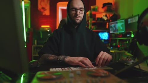 Un hacker écrit du code et un programmeur informatique dans un système Hoodie Cacks utilisant un ordinateur dans le noir