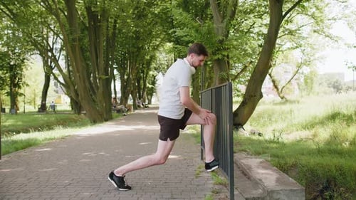 Man Stretching Legs in Sunny Park