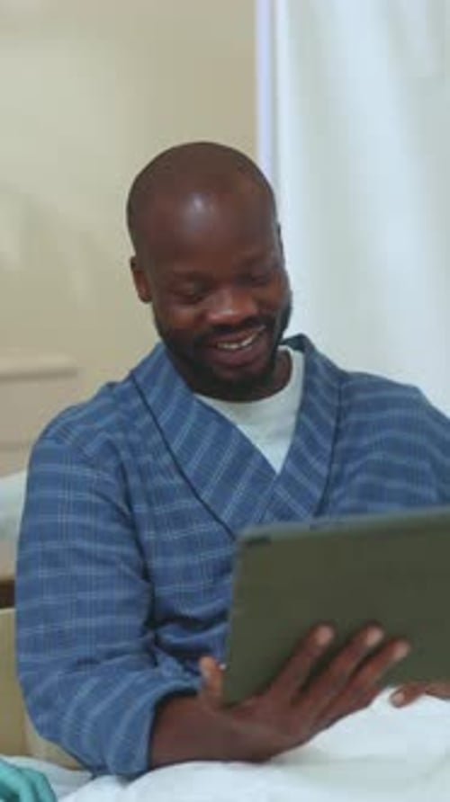 A Relaxed Man Enjoying Digital Content While Wearing a Comfortable Bathrobe at Home