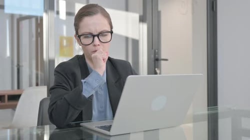 Businesswoman Coughing While Working on Laptop in Office
