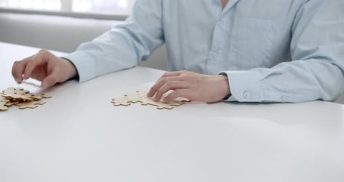 Young Man Assembling Wooden Puzzle for Business Collaboration Ideas