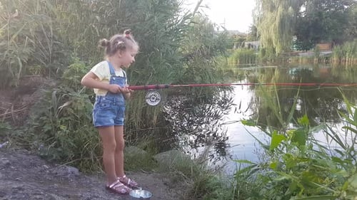 Ein vierjähriges Mädchen fischt am Fluss