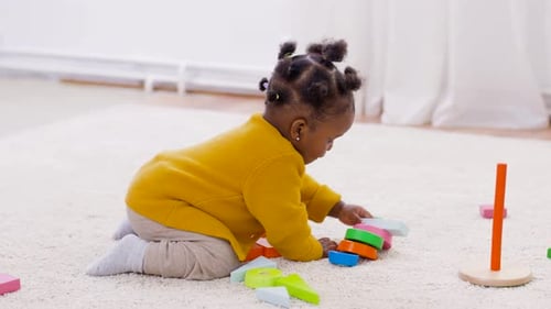 Infant plays with colorful wooden toy blocks indoors