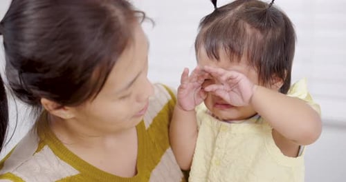 Crying Baby Being Comforted by Woman