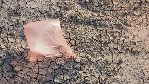 Una bolsa de plástico vuela en tierra seca: desastre ambiental
