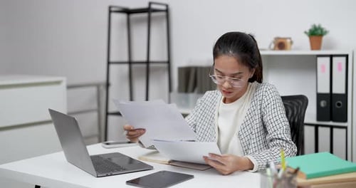 Woman Works at Desk, Reviews Business Documents