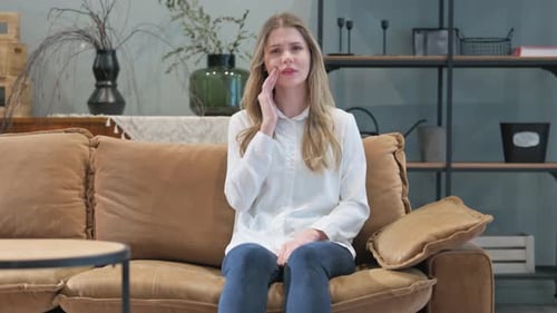 Woman with Toothache Sitting on Sofa at Home