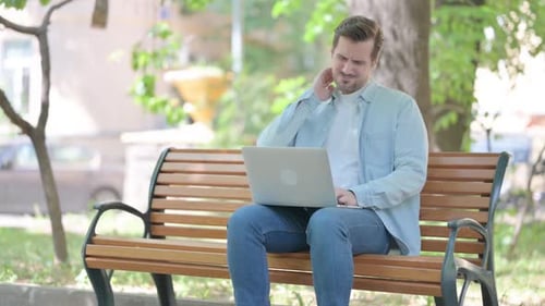 Man Sitting on Bench Using Laptop with Neck Pain