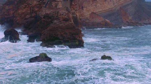 Waves Powerfully Crashing Against Rocky Coastal Cliffs