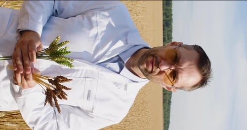 Man in Field Holding Wheat Crop Sample
