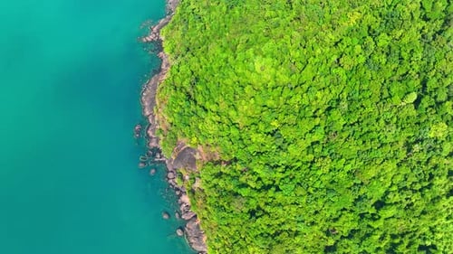 Aerial view reveals lush coastal and mountains on tropical island. 4K.