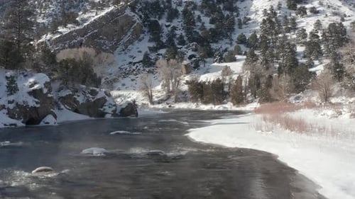 Snowy Mountain River with ice flow and fog