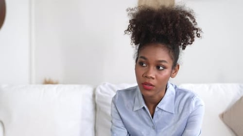Concerned Woman Comforts Friend on Couch in Living Room