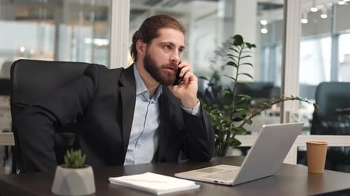 Bearded Man Talking on Phone at Modern Office