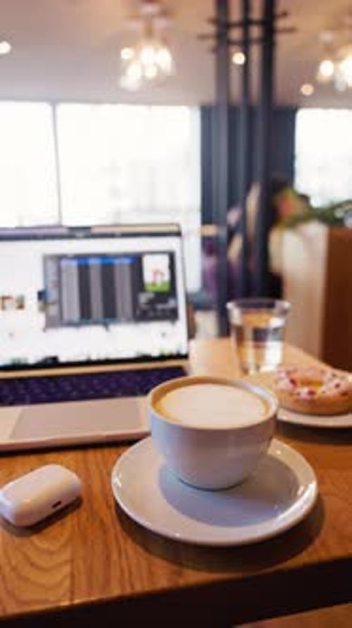 A Cozy Coffee Shop Workspace Featuring a Laptop Delicious Pastry and a Warm Atmosphere for