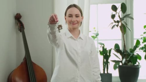 Woman Holding Keys in Bright Apartment
