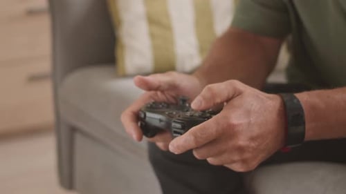Hands Play Video Game Indoors on Couch