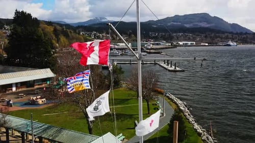 British Canadian Flags Waving At The Historical Marker In Port Alberni, BC, Canada. aerial, closeup
