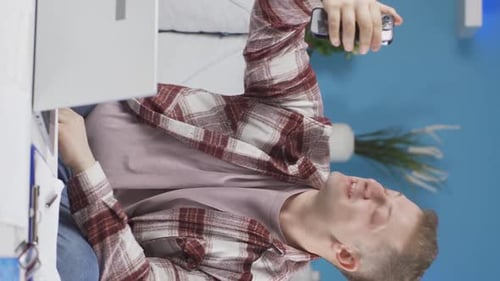 Vertical video of Home office worker man talking on the phone facetime happily.