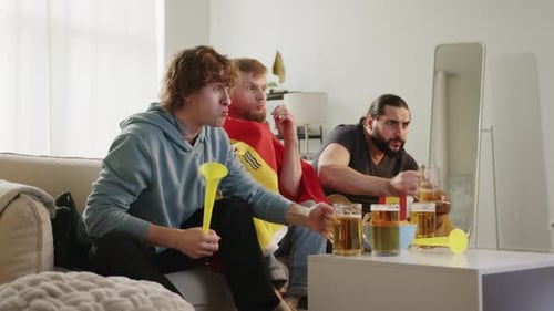 Joyful Football Fans Cheering for Favorite Team While Watching Match on TV Sitting at Home