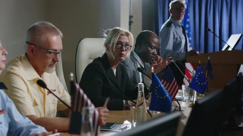 Adults at Meeting with Flags and Speaker