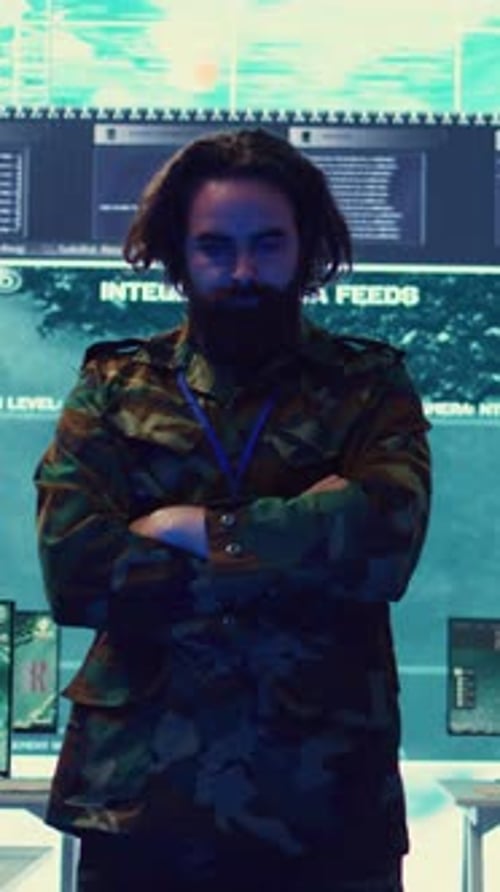 Bearded Man in Camouflage Jacket Gesturing at Screens